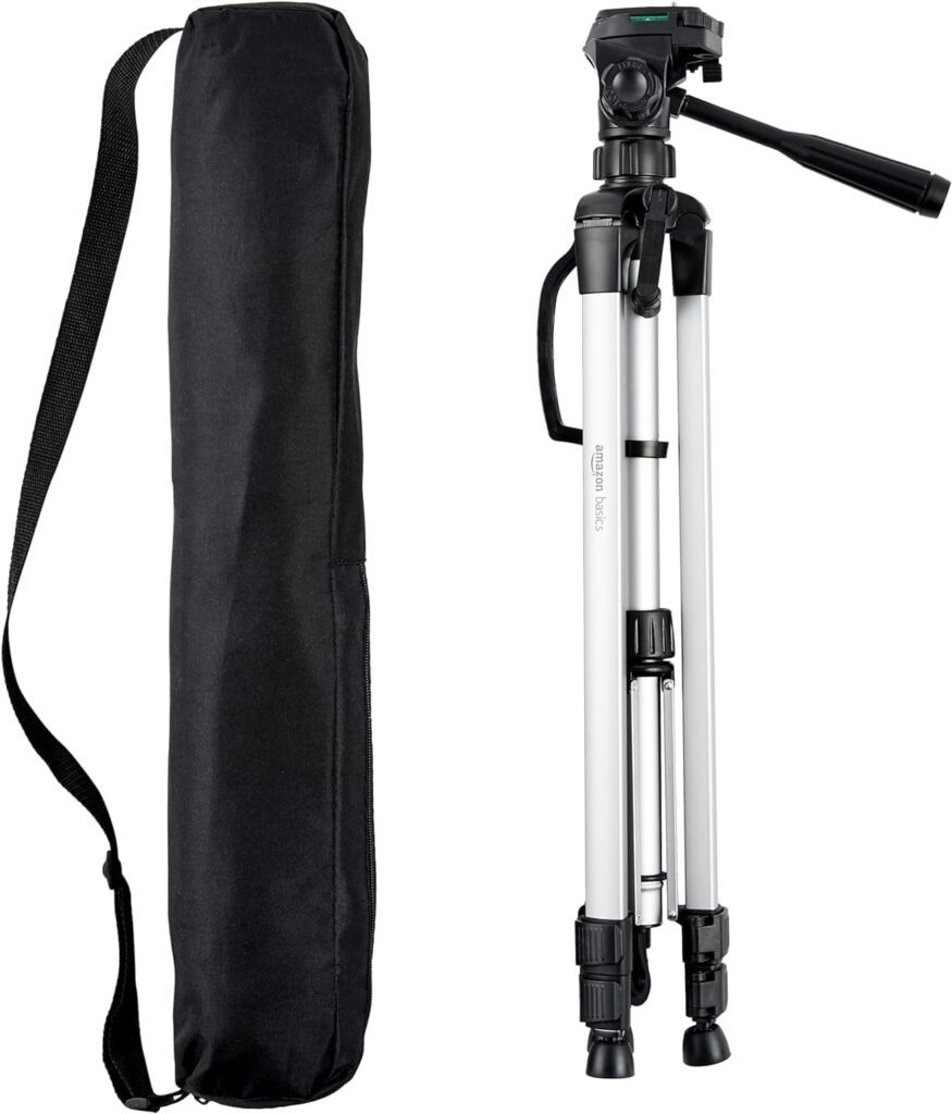 An aluminum tripod with a pan head, next to a black carrying case with a strap, both from Amazon Basics.