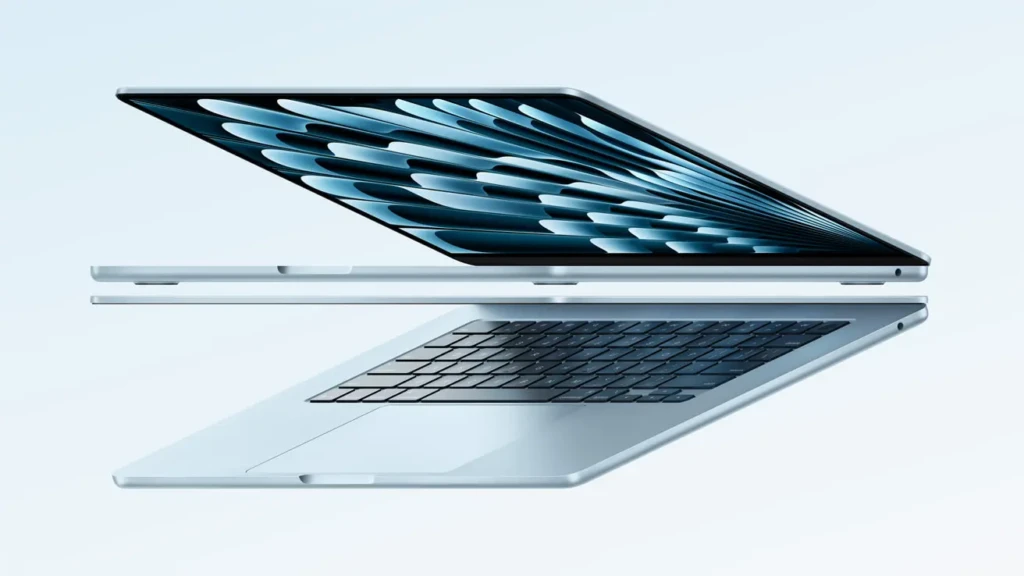 A sleek silver laptop positioned at an angle, showcasing its keyboard and vibrant screen design against a soft gradient background.