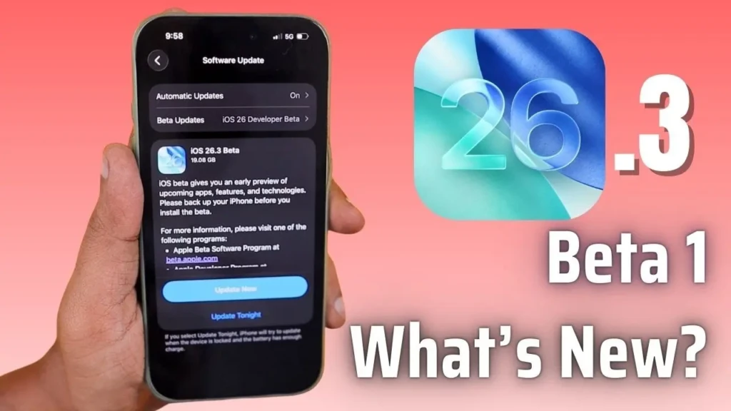 A hand holding an iPhone displaying the iOS 26.3 Beta update screen, with the text "What's New?" alongside a colorful graphic.