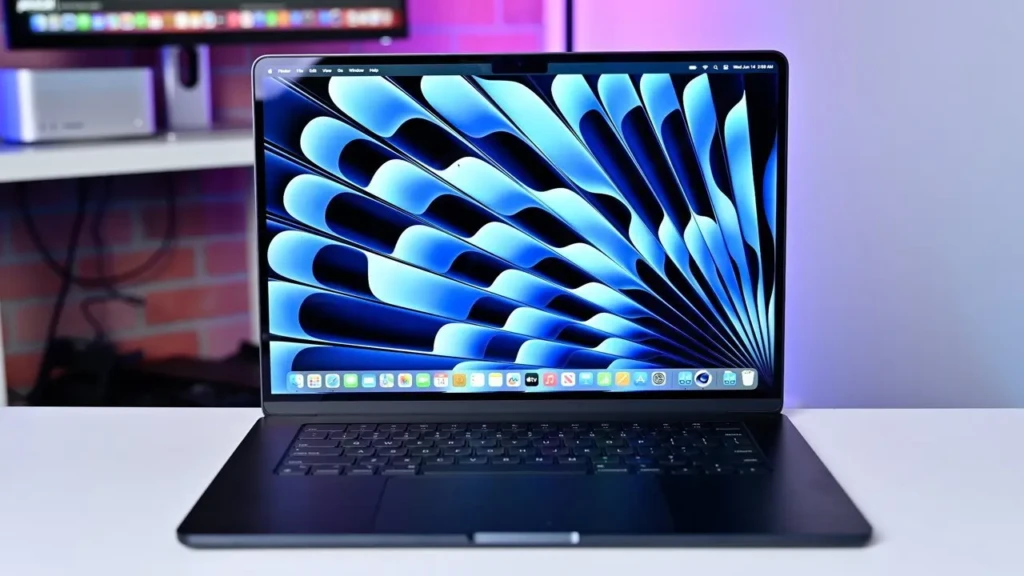 A sleek laptop with a vibrant blue abstract wallpaper displayed on its screen, set on a modern desk.