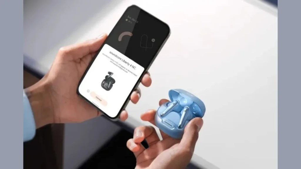 A person holding a pair of blue earbuds and a smartphone displaying a connection screen for the earbuds.