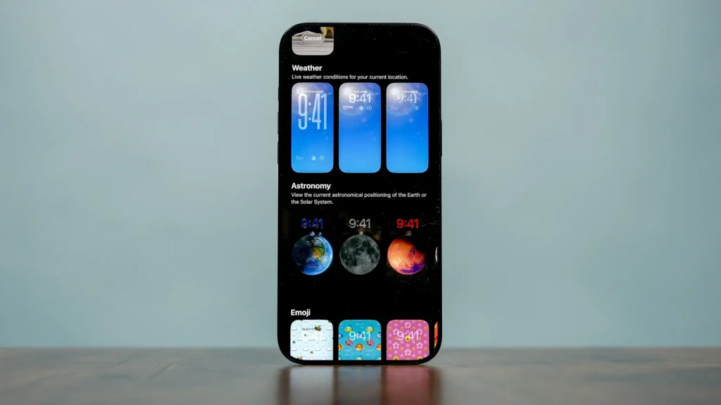 A smartphone displaying app options for Weather, Astronomy, and Emoji, with various colorful icons and live time indicators.