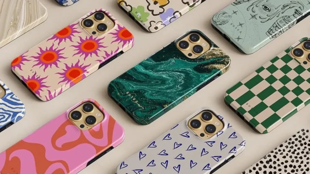 Collection of smartphones laid flat showing various colorful patterned cases including abstract shapes hearts checkered and marble designs