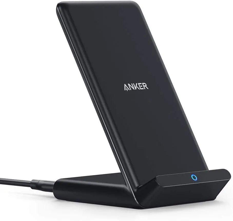 A black Anker wireless charging stand with a sleek angled design, featuring the Anker logo and a glowing blue LED indicator light at the base, highlighting its minimalist aesthetic and upright charging position for smartphones on a clean white background.