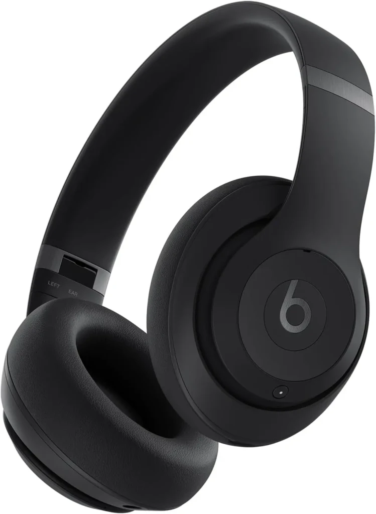 A matte black Beats Studio Pro over-ear headphone displayed against a white backdrop, featuring the iconic “b” logo on the earcup and “LEFT EAR” marking on the headband, showcasing its minimalist aesthetic and professional audio design.