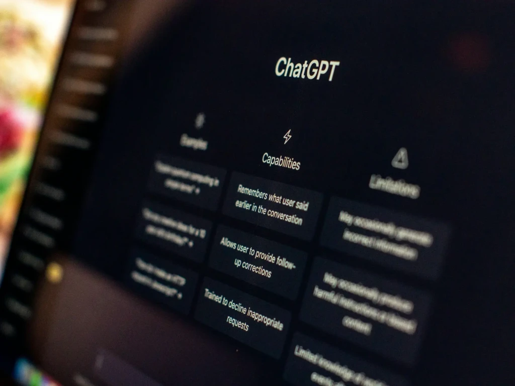 A close-up of a computer screen showing a ChatGPT interface highlighting its “Capabilities,” such as remembering conversation history and allowing user corrections, alongside sections for “Samples” and “Limitations,” providing a balanced view of its strengths and constraints.