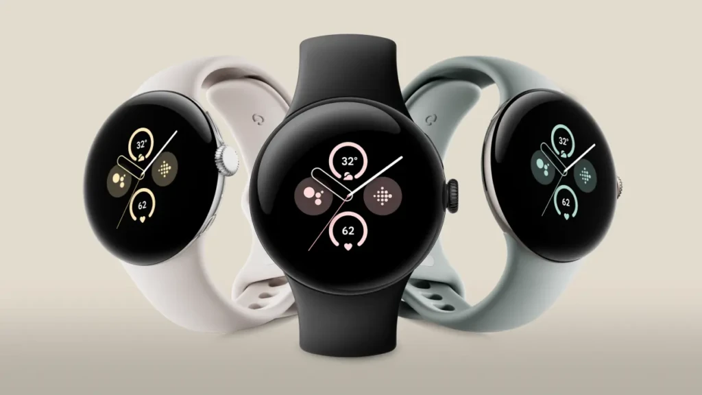 Three Google Pixel Watches in black, white, and sage green straps arranged side by side, all showing similar analog-style faces with weather and heart rate data, illustrating color options and consistent design across variants for personalized style and everyday wear.