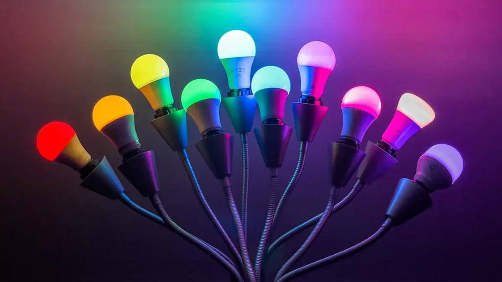 A cluster of Wyze smart bulbs mounted on flexible arms, each glowing in a different vivid color against a dark background, highlighting their RGB lighting range and decorative potential for mood lighting or entertainment environments.
