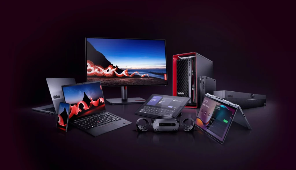 A collection of Lenovo ThinkBook devices, including laptops, a monitor, a desktop, and tablets, on a dark background