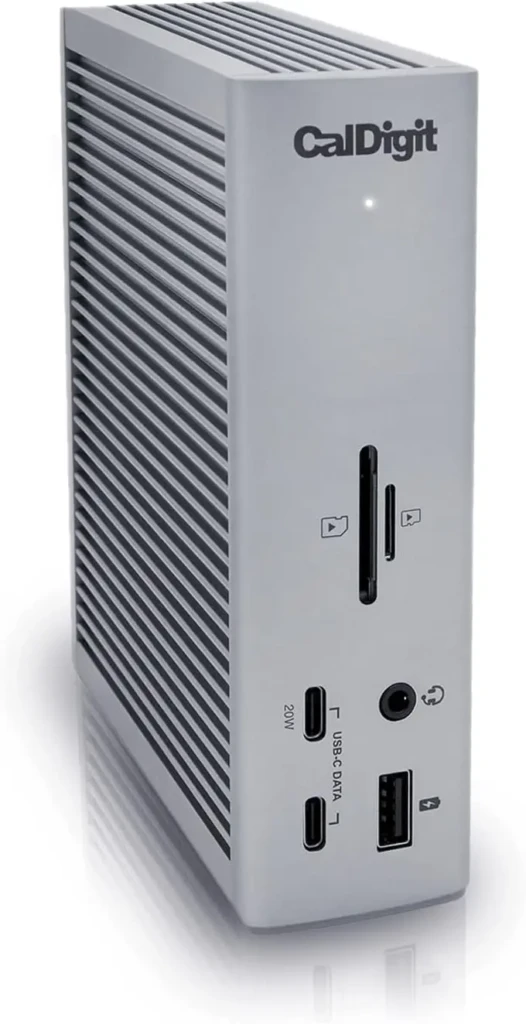 A silver CalDigit TS3 Plus dock with vertical finned散热 vents on the left, front-facing ports including SD/microSD slots, USB-C (20W), USB-A, headphone jack, and power indicator, emphasizing its robust build and multimedia-ready I/O for creative professionals.