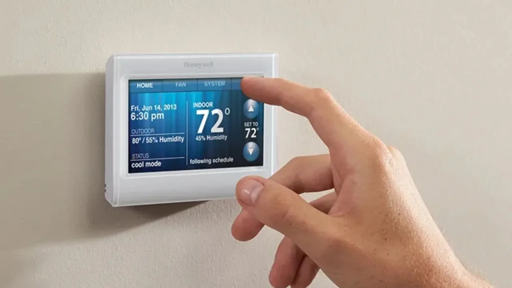 A hand interacting with a Honeywell touchscreen thermostat displaying detailed environmental data: indoor temperature 72°F, 45% humidity, outdoor 80°F/55% humidity, and “cool mode” active, demonstrating advanced monitoring and scheduling capabilities on a modern smart model.