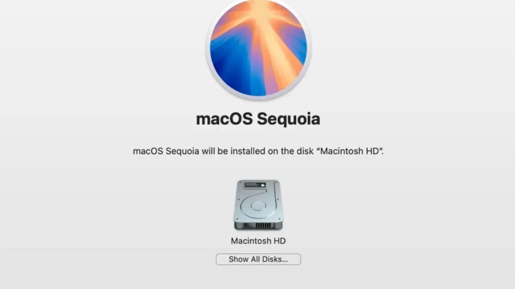 The macOS Sequoia installation screen showing the operating system logo (a radiant blue-and-orange sunburst), the text “macOS Sequoia,” a note stating “macOS Sequoia will be installed on the disk ‘Macintosh HD’,” and a visual representation of the Macintosh HD drive with a “Show All Disks…” button below, indicating the final step before OS installation.