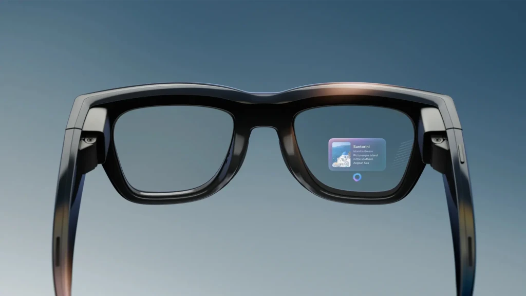 Front-facing view of black smart glasses displaying an augmented reality card identifying “Santorini” with an image and description, overlaid on the right lens, illustrating real-time contextual information delivery in a travel or exploration use case.
