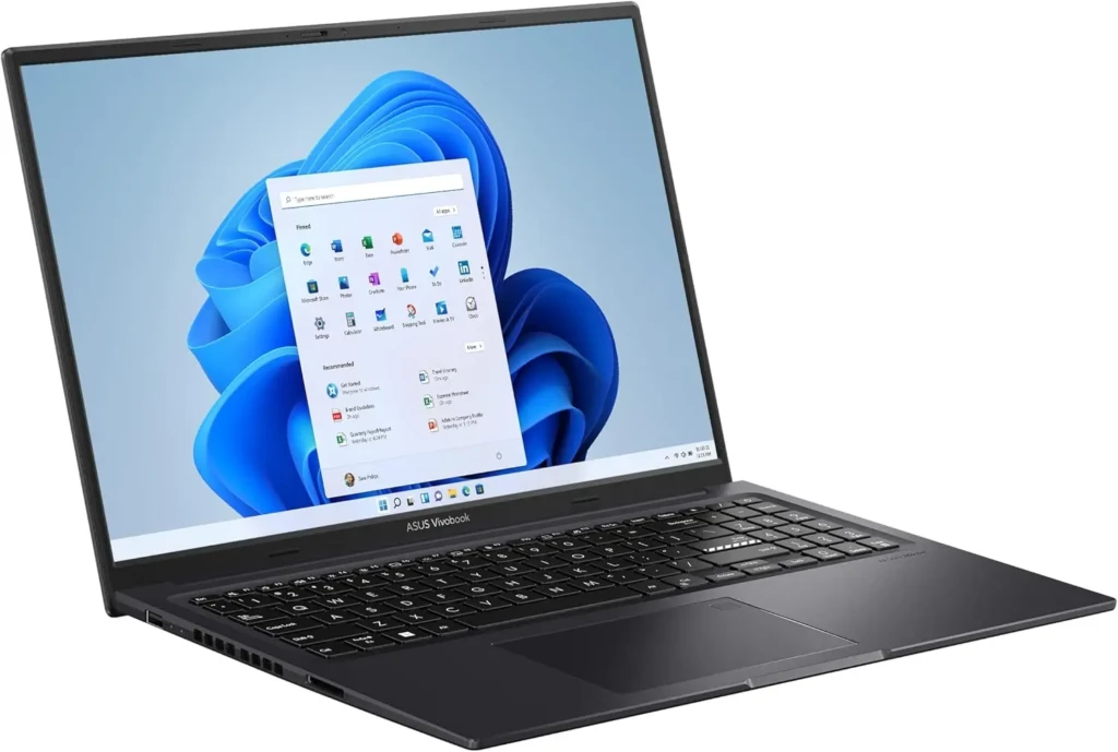 A black ASUS Vivobook laptop open to the Windows 11 Start menu, displaying pinned apps (Edge, Word, Excel, etc.) and recommended items against the default blue wave wallpaper, showcasing a consumer-grade productivity device with modern OS integration.