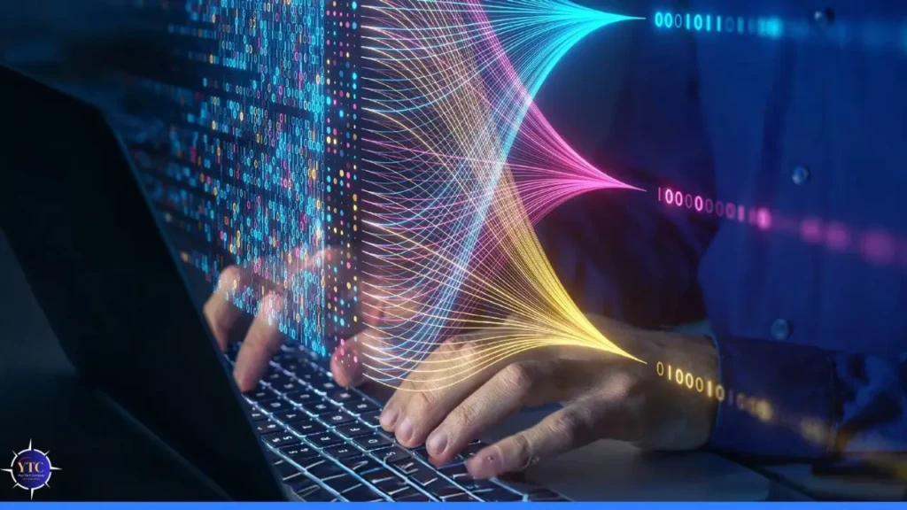 A person typing on a laptop keyboard with vibrant, multicolored data streams (blue, pink, yellow) flowing from the screen into their hands, overlaid with binary code and glowing circuit patterns, symbolizing AI-augmented coding, real-time data processing, and human–machine collaboration.
