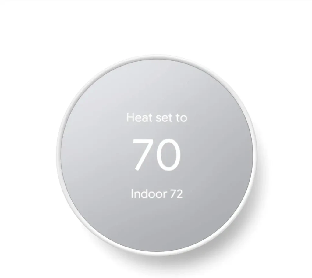 A circular Nest Learning Thermostat displaying “Heat set to 70” and “Indoor 72” in white text on a brushed-metal face, illustrating intuitive temperature control and real-time indoor monitoring.