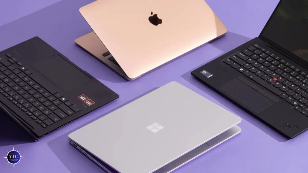 Four laptops arranged a purple surface: a black Lenovo ThinkPad, a gold MacBook, a silver Microsoft Surface Laptop, and a black ASUS model, representing a cross-brand comparison of premium portable computing devices for professionals and creators.