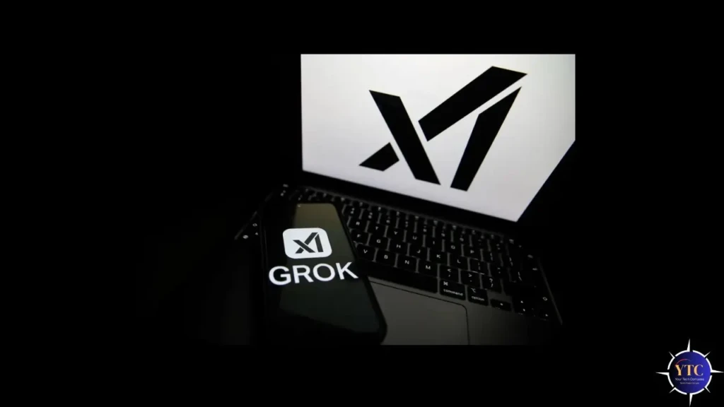 A smartphone displaying the “GROK” logo resting on a laptop keyboard, with the xAI logo visible on the laptop screen in the background, symbolizing the integration of Grok AI across mobile and desktop platforms.