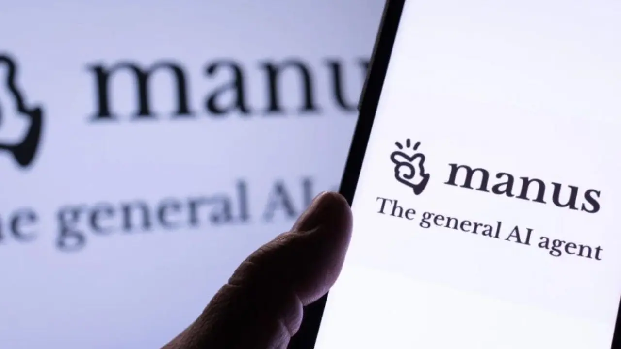 A hand holds a smartphone displaying the "manus" logo with the tagline "The general AI agent." The logo also appears blurred in the background.