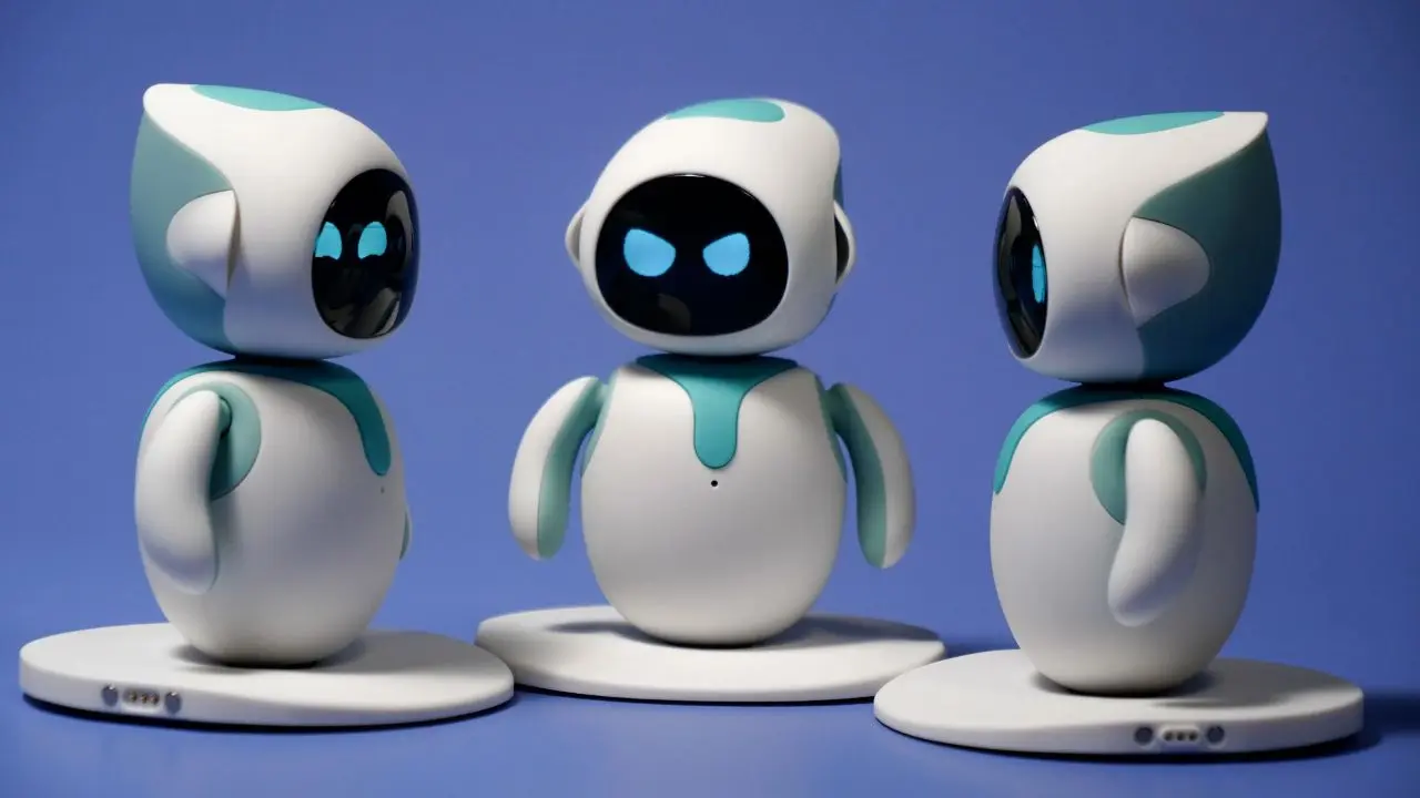 Three cute, rounded robots with white and teal designs stand on a blue backdrop. They have large black faces with glowing blue eyes, appearing playful.
