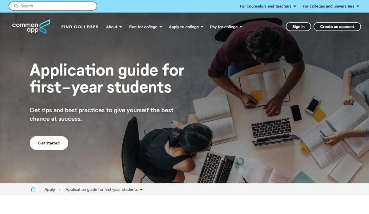 A group of students sit around a table covered with notebooks and laptops, viewed from above. The text reads "Application guide for first-year students." The atmosphere is collaborative and focused.