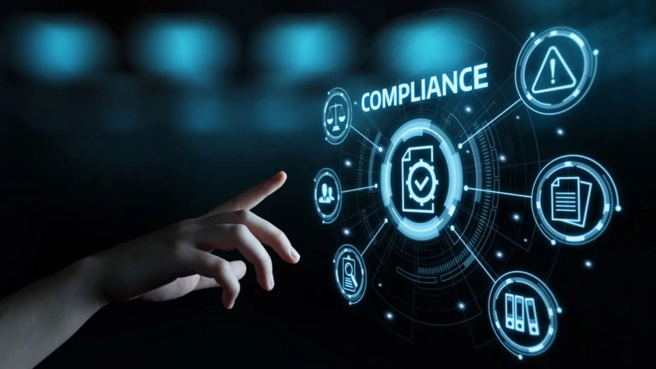 A hand reaches towards a holographic interface displaying the word "COMPLIANCE" surrounded by icons like scales, a warning sign, and documents, conveying a futuristic tech theme.