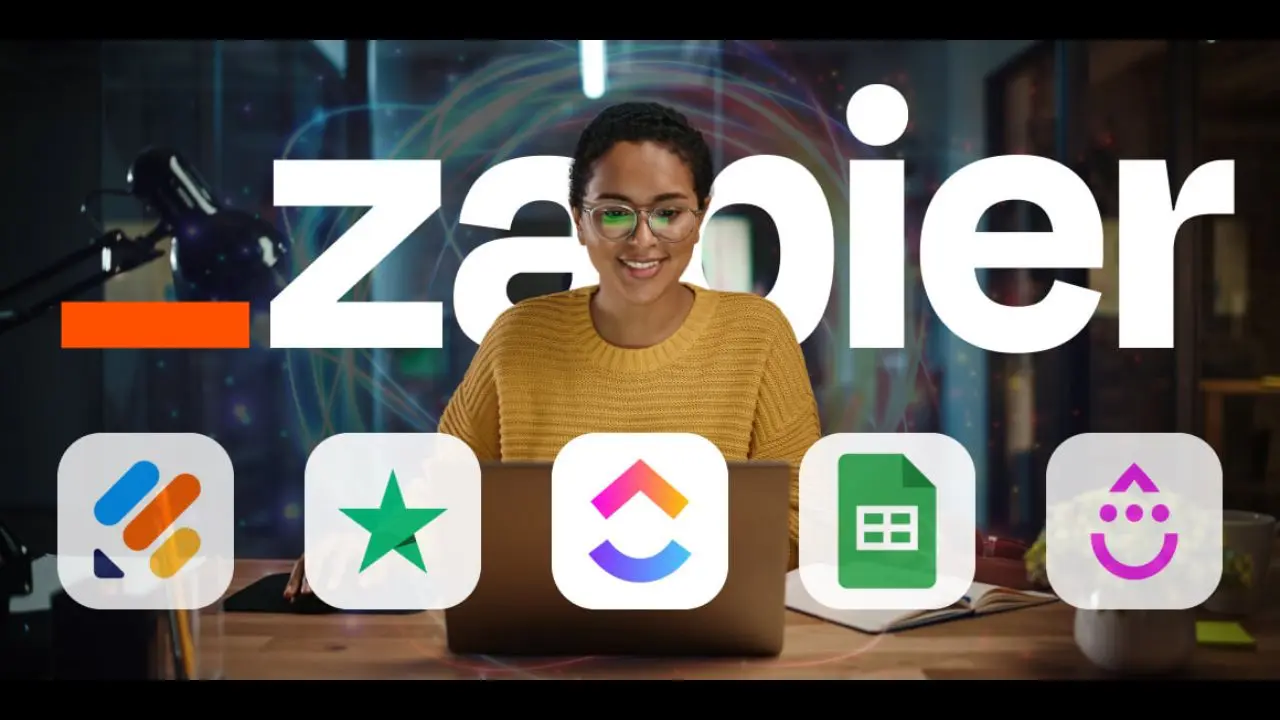 A person smiling at a laptop, surrounded by app icons, with "Zapier" in bold white text behind. The scene conveys productivity and integration.