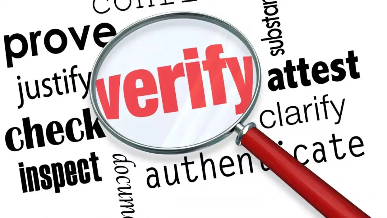 A large magnifying glass emphasizes the word "verify" in red, surrounded by black words like "check," "prove," and "attest," suggesting investigation and validation.
