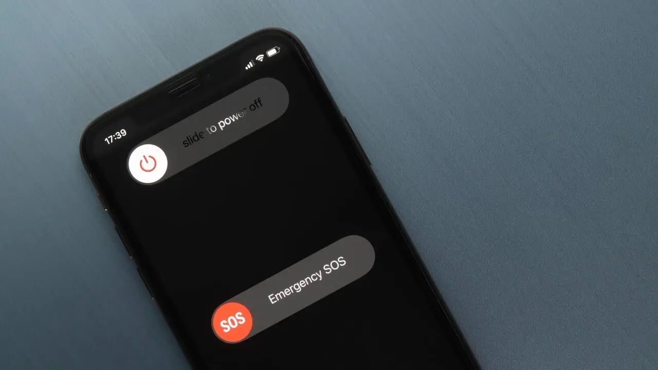 Smartphone screen displaying 'slide to power off' and 'Emergency SOS' options against a dark metallic background, indicating urgency.