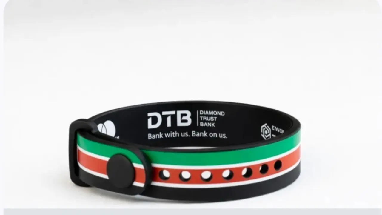 A black wristband displays "DTB Diamond Trust Bank" and "Bank with us. Bank on us." with red, green, and white stripes and multiple adjustment holes.