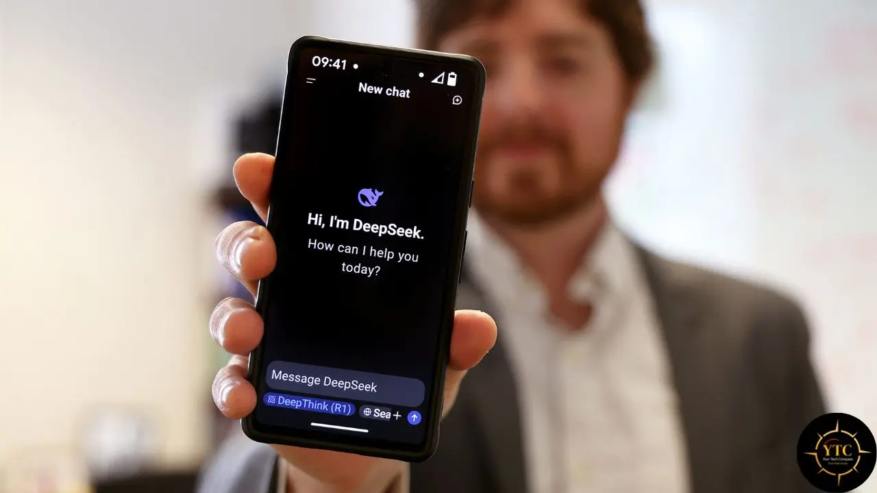 A person holds a smartphone displaying the DeepSeek AI chatbot interface with the greeting "Hi, I'm DeepSeek. How can I help you today?".