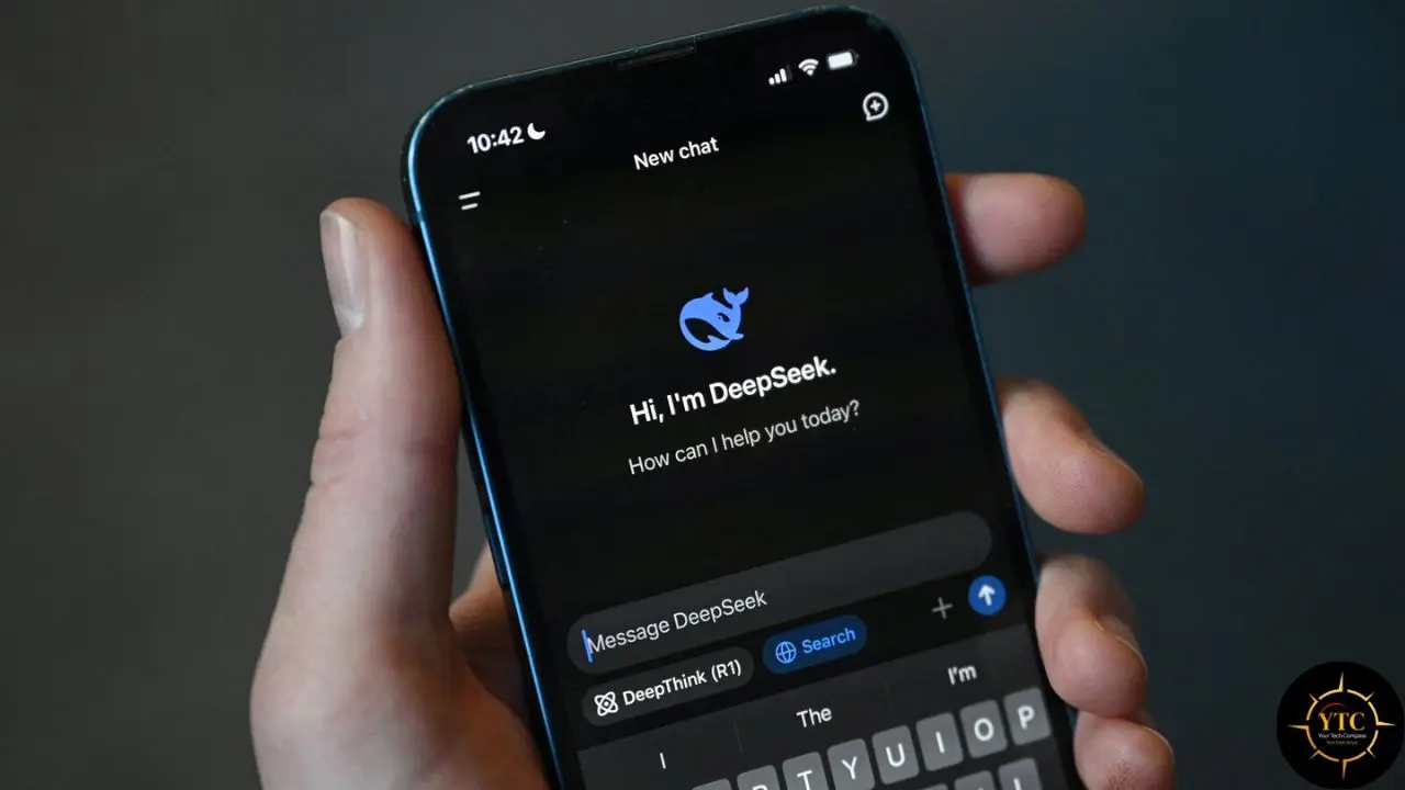 A hand holds a smartphone displaying the DeepSeek AI chatbot interface with a welcome message and keyboard.