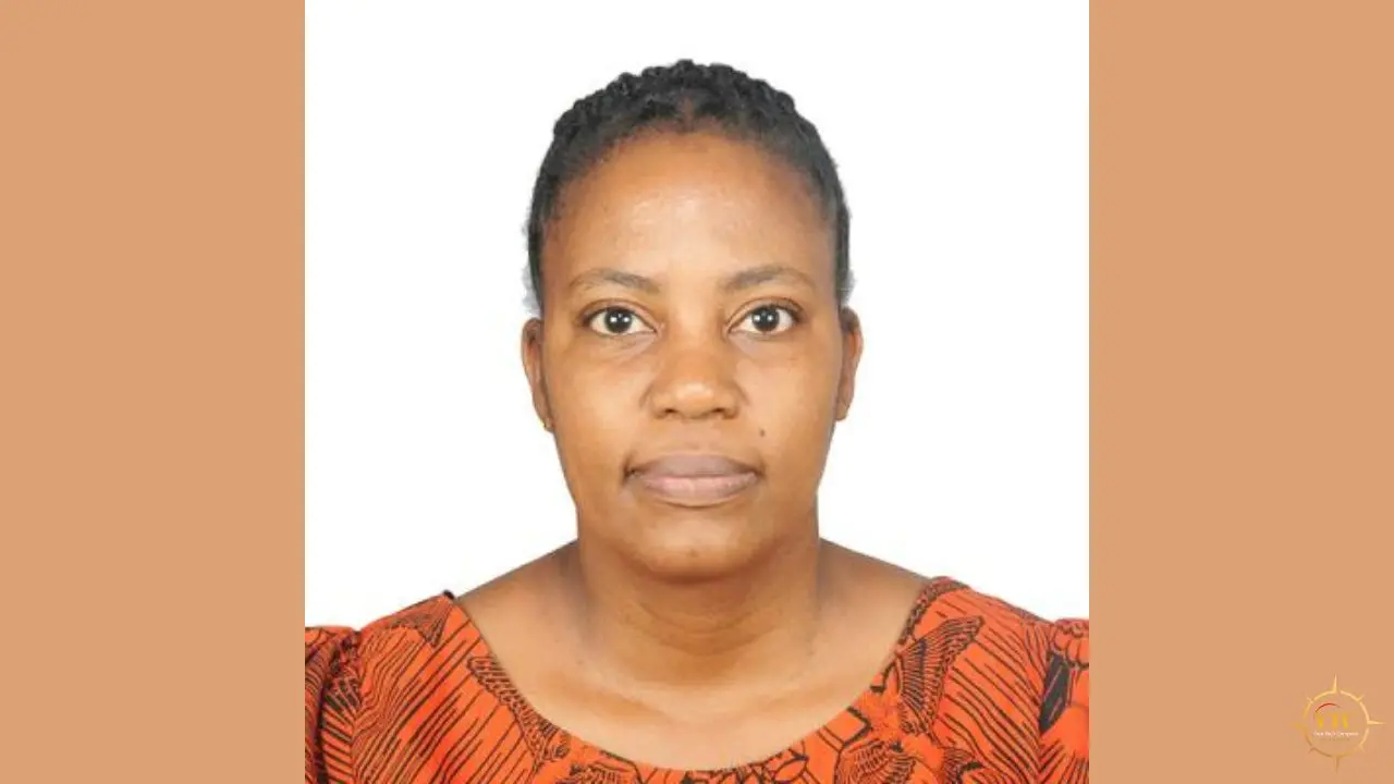 Headshot of a Black woman with braided hair and an orange patterned top against a white and tan background.